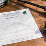 Licença de pesca emitida pelo Ibama ao lado de equipamentos de pesca esportiva